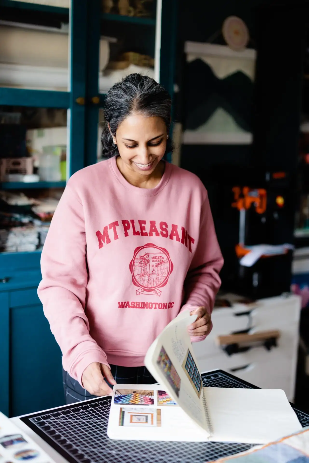 Aarti Ravi flipping through her design notebook.